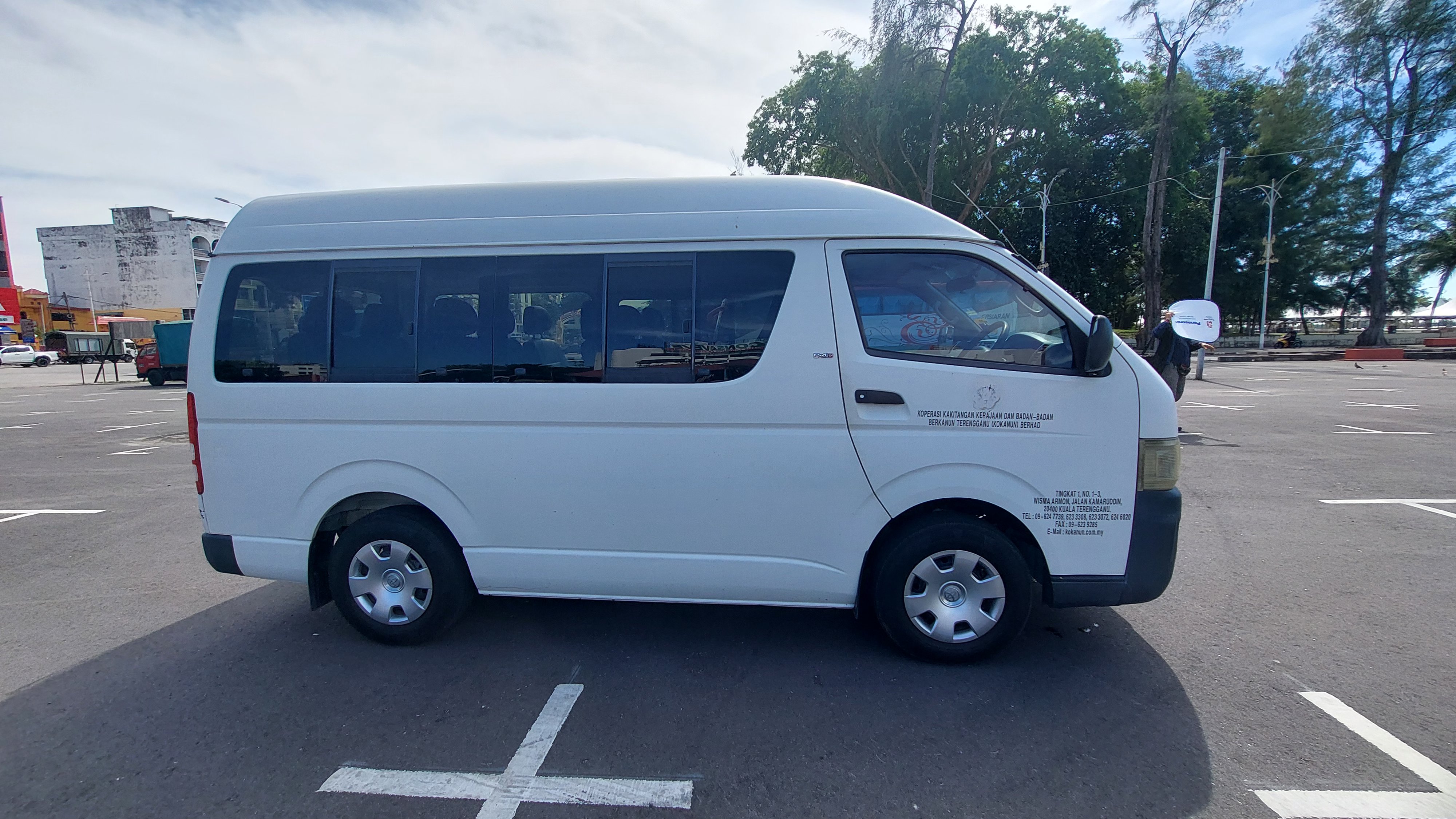 Van sewa Toyota Hiace berwarna putih milik KOKANUN Travel, sedia untuk disewa.